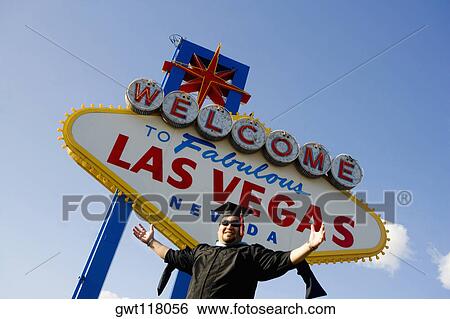 Low angle view of a young man standing in font of a Las Vegas sign board, Las Vegas, Nevada, USA View Large Photo Image Stock Photograph - Low angle view of a young man standing in font of a Las Vegas sign board, Las Vegas, Nevada, USA. Fotosearch