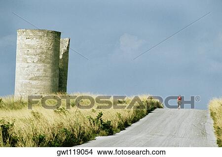 Front view of a solitary woman walking along a road on a sunny day, Eleuthera, Bahamas View Large Photo Image Picture - Front view of a solitary woman walking along a road on a sunny day, Eleuthera, Bahamas. Fotosearch