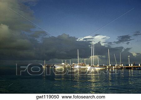 Stock Image - Scenic view of boats anchored to a marina at sunset, Grand Bahamas, Bahamas. Fotosearch
