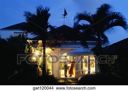 Picture - A couple is seen standing at the door of Bon Vivant Villa, Barbados, Caribbean. Fotosearch