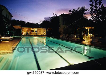 Stock Photo - An illuminated pool is seen at the Bon Vivant Villa on the island of Barbados, Caribbean. Fotosearch