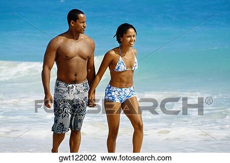 A couple walking near a seashore, Natural Arches Beach, Bahamas View Large Photo Image Stock Image - A couple walking near a seashore, Natural Arches Beach, Bahamas. Fotosearch