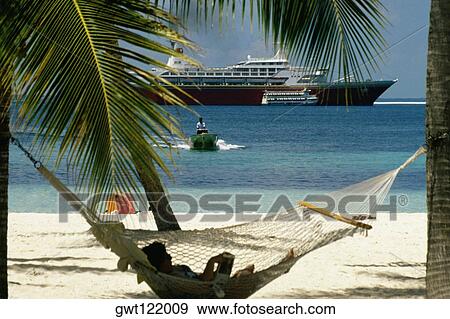 A woman relaxing on a hammock on a beach, Treasure Island, Abaco, Bahamas View Large Photo Image Stock Photo - A woman relaxing on a hammock on a beach, Treasure Island, Abaco, Bahamas. Fotosearch