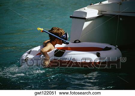 Boy wearing a scuba floating on a lifesaving ring View Large Photo Image Stock Image - Boy wearing a scuba floating on a lifesaving ring. Fotosearch