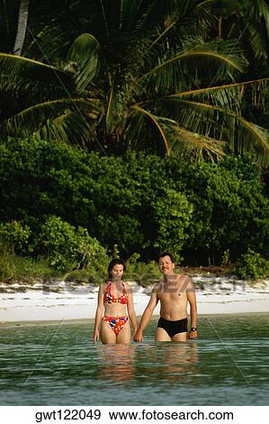 Couple in bathing suit stand knee-deep immersed in water, Abaco, Bermuda View Large Photo Image Stock Photo - Couple in bathing suit stand knee-deep immersed in water, Abaco, Bermuda. Fotosearch