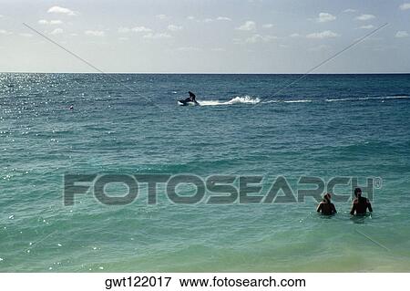 Rear view of a couple standing amidst the vast ocean, Lucayan Beach Resort, Freeport, Bahamas View Large Photo Image Stock Photo - Rear view of a couple standing amidst the vast ocean, Lucayan Beach Resort, Freeport, Bahamas. Fotosearch