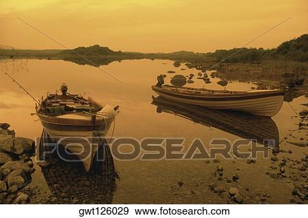 Reflection of boats in a lake, Ross lake, County Galway, Republic of Ireland View Large Photo Image Stock Photo - Reflection of boats in a lake, Ross lake, County Galway, Republic of Ireland. Fotosearch