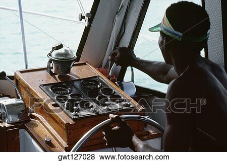 A boat captain navigates a powerboat off the shore of Jamaica View Large Photo Image Stock Photo - A boat captain navigates a powerboat off the shore of Jamaica. Fotosearch