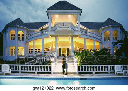 A couple kiss in front of the illuminated Endless Summer Villa, Jamaica View Large Photo Image Stock Image - A couple kiss in front of the illuminated Endless Summer Villa, Jamaica. Fotosearch