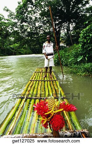 A man is standing on a bamboo raft floating down the Martha Brae River, Jamaica View Large Photo Image Stock Photography - A man is standing on a bamboo raft floating down the Martha Brae River, Jamaica. Fotosearch