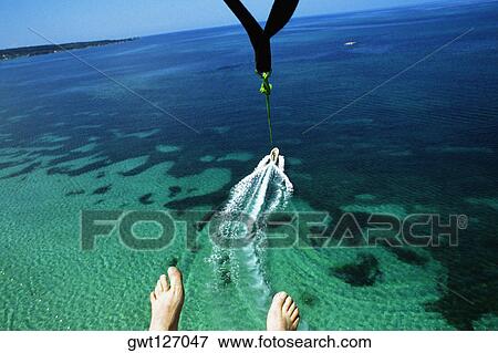 A mans feet are seen as he parasail over Negril Beach, Jamaica View Large Photo Image Stock Photo - A mans feet are seen as he parasail over Negril Beach, Jamaica. Fotosearch