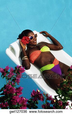 An African-American woman is floating on an inflatable mattress in a swimming pool, Destiny Villa, Jamaica View Large Photo Image Stock Photograph - An African-American woman is floating on an inflatable mattress in a swimming pool, Destiny Villa, Jamaica. Fotosearch