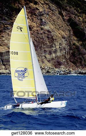 Stock Photograph - A sailboat participates in the Heiniken Regatta on the Dutch side of the island of St. Maarten in the Caribbean. Fotosearch