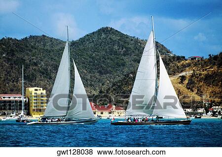 Two sailboats are seen participating in the Heiniken Regatta on the Dutch side of the island of St. Maarten in the Caribbean View Large Photo Image Stock Photo - Two sailboats are seen participating in the Heiniken Regatta on the Dutch side of the island of St. Maarten in the Caribbean. Fotosearch