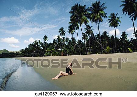Stock Photo - A woman relaxing on a beach, Puerto Rico. Fotosearch