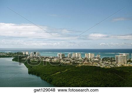 Stock Photo - High angle view of a coastal city with lush vegetation, San Juan, Puerto Rico. Fotosearch