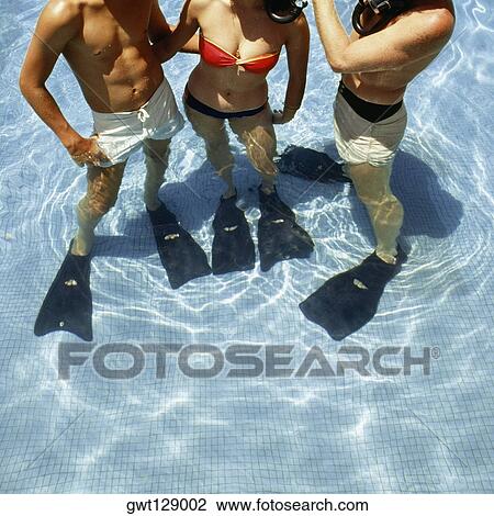 Stock Image - Three swimmers with flippers and snorkels in a swimming pool, La Concha Hotel, San Juan, Puerto Rico. Fotosearch