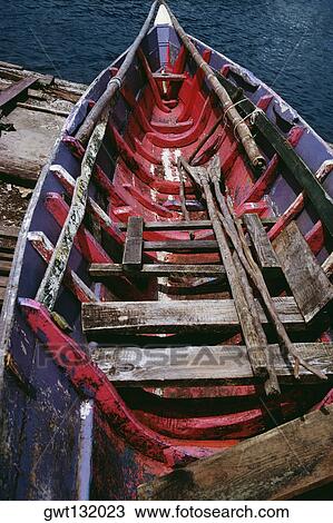 Stock Image - An old painted boat with an oar. Fotosearch