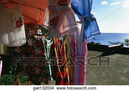Picture - Dresses are displayed for sale at a souvenir stand on the island of Martinique.. Fotosearch
