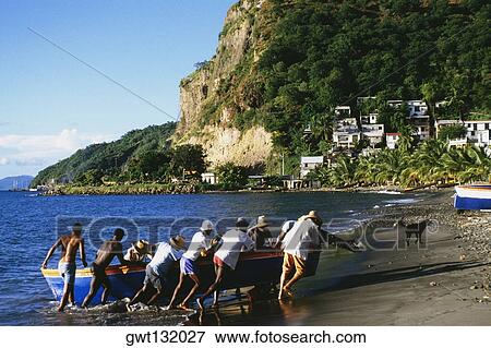 Natives pushing a boat onto a shore near the town of Castries, St. Lucia View Large Photo Image Stock Photo - Natives pushing a boat onto a shore near the town of Castries, St. Lucia. Fotosearch