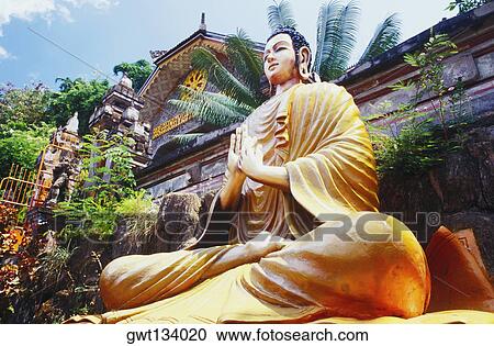 Low angle view of a statue of Buddha in front of a building, Bali, Indonesia View Large Photo Image Stock Image - Low angle view of a statue of Buddha in front of a building, Bali, Indonesia. Fotosearch
