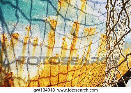 Shadow of a net on a rusty boat, Bali, Indonesia View Large Photo Image Stock Photo - Shadow of a net on a rusty boat, Bali, Indonesia. Fotosearch