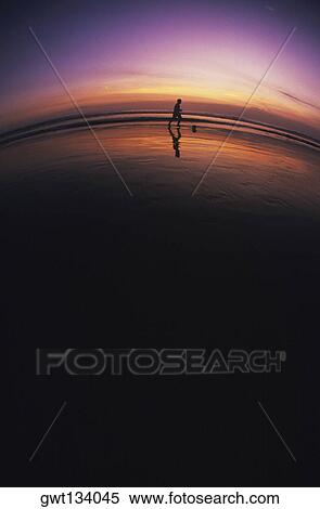 Stock Photography - Silhouette of a person running on the beach, Bali, Indonesia. Fotosearch