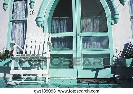 Rocking chair in front of a closed door View Large Photo Image Stock Image - Rocking chair in front of a closed door. Fotosearch