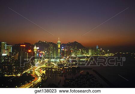 Stock Image - High angle view of buildings in a city lit up at night, Hong Kong, China. Fotosearch