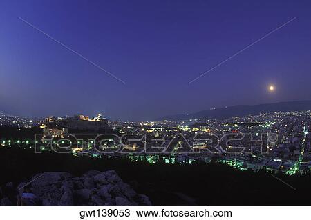 High angle view of buildings in a city lit up at dusk View Large Photo Image Stock Image - High angle view of buildings in a city lit up at dusk. Fotosearch