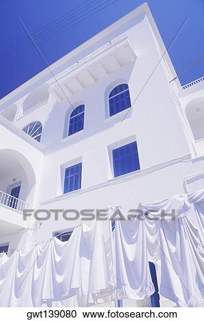 Low angle view of clothes hanging on a clothesline in front of a building View Large Photo Image Stock Image - Low angle view of clothes hanging on a clothesline in front of a building. Fotosearch