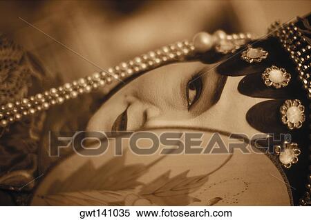 Stock Photography - Close-up of a female opera performer covering her face with a fan, Hong Kong, China. Fotosearch