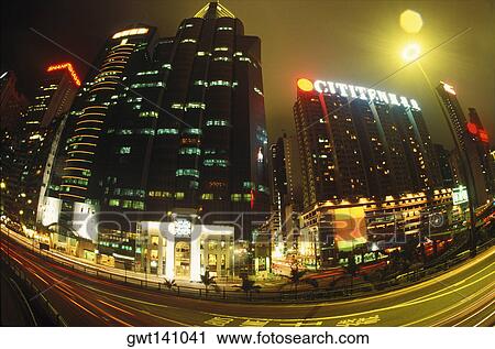 Stock Image - Low angle view of skyscrapers in a city lit up at night, Hong Kong, China. Fotosearch