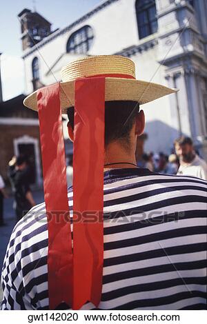 Stock Image - Rear view of a person wearing a straw boater hat, Italy. Fotosearch