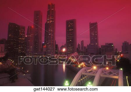 Stock Photo - Skyscrapers in a city lit up at night, Singapore. Fotosearch