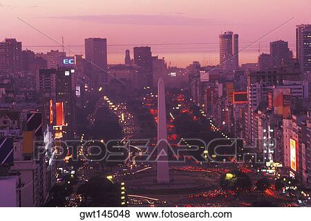 Stock Photo - High angle view of buildings lit up at dusk. Fotosearch