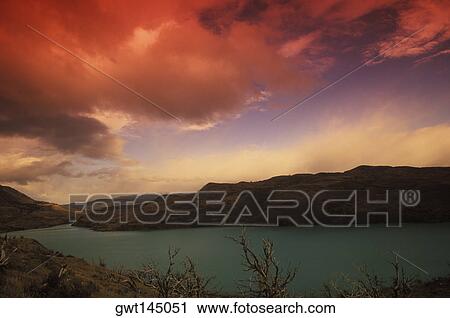 Stock Image - Rainy clouds over mountains at dusk. Fotosearch