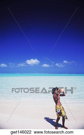 High angle view of a young man blowing a conch shell on the beach, Hawaii, USA View Large Photo Image Stock Image - High angle view of a young man blowing a conch shell on the beach, Hawaii, USA. Fotosearch