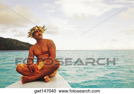 Stock Image - Close-up of a young man sitting on a ship's bow, Hawaii, USA. Fotosearch