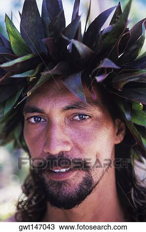 Stock Image - Portrait of a young man wearing a headdress, Hawaii, USA. Fotosearch