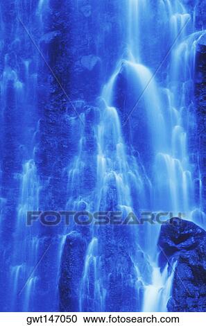 Stock Image - Water flowing from a waterfall. Fotosearch