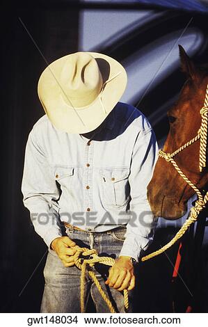 Close-up of a cowboy tying a rein View Large Photo Image Picture - Close-up of a cowboy tying a rein. Fotosearch
