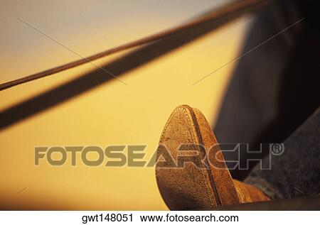 Stock Image - Close-up of a person's foot wearing a cowboy boot. Fotosearch