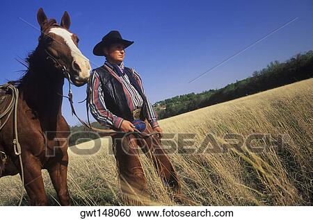 Cowboy standing with a horse on a field, Texas, USA View Large Photo Image Stock Image - Cowboy standing with a horse on a field, Texas, USA. Fotosearch