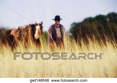 Cowboy standing with a horse, Texas, USA View Large Photo Image Stock Photo - Cowboy standing with a horse, Texas, USA. Fotosearch