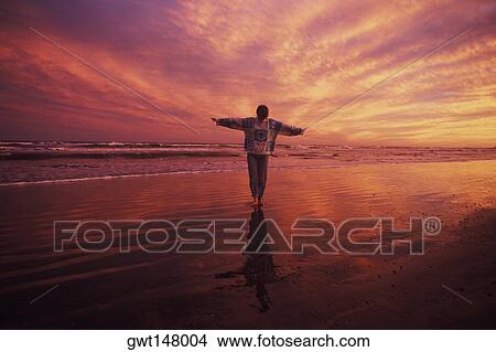 Man standing on the beach with his arms outstretched, Texas, USA View Large Photo Image Picture - Man standing on the beach with his arms outstretched, Texas, USA. Fotosearch