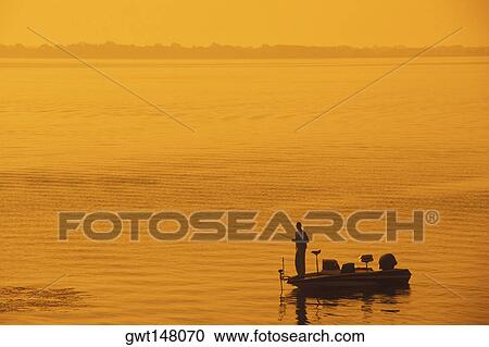 Stock Image - Silhouette of a man fishing in the sea, Texas, USA. Fotosearch