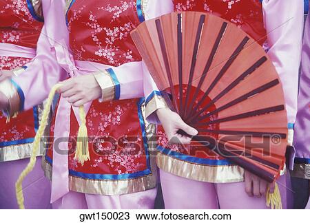Mid section view of three women holding a folding fan and a rope View Large Photo Image Stock Image - Mid section view of three women holding a folding fan and a rope. Fotosearch