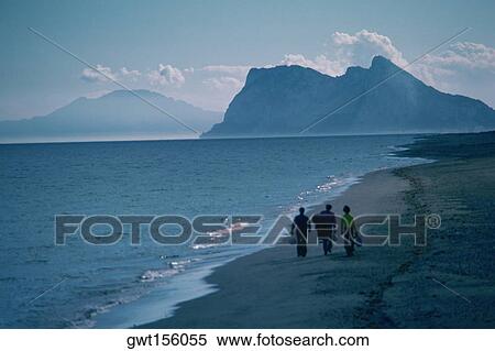 Three people walking on the beach, Rock of Gibraltar, Gibraltar, Spain View Large Photo Image Stock Photography - Three people walking on the beach, Rock of Gibraltar, Gibraltar, Spain. Fotosearch