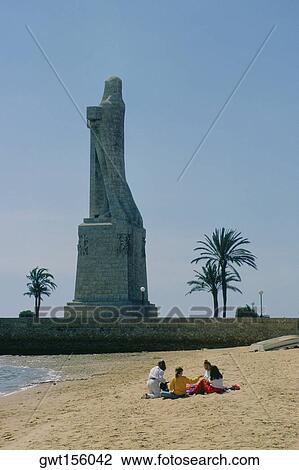 Tourist sitting on the beach near a monument, Christopher Columbus, Spain View Large Photo Image Stock Image - Tourist sitting on the beach near a monument, Christopher Columbus, Spain. Fotosearch